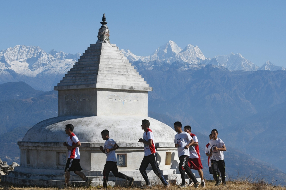 Buddhist monks are seen running during a training session in Sindhukot village, some 80 kilometers northeast of Kathmandu, Nepal. Swapping their maroon robes for running shoes, seven Buddhist monks take off at a sprint across the hills surrounding their remote village in the foothills of Nepal's Himalayas. They are aspiring ultra-marathon runners, hoping the sport will put their remote village on the map and provide the funds needed to rebuild homes destroyed by a massive earthquake nearly three years ago. - AFP