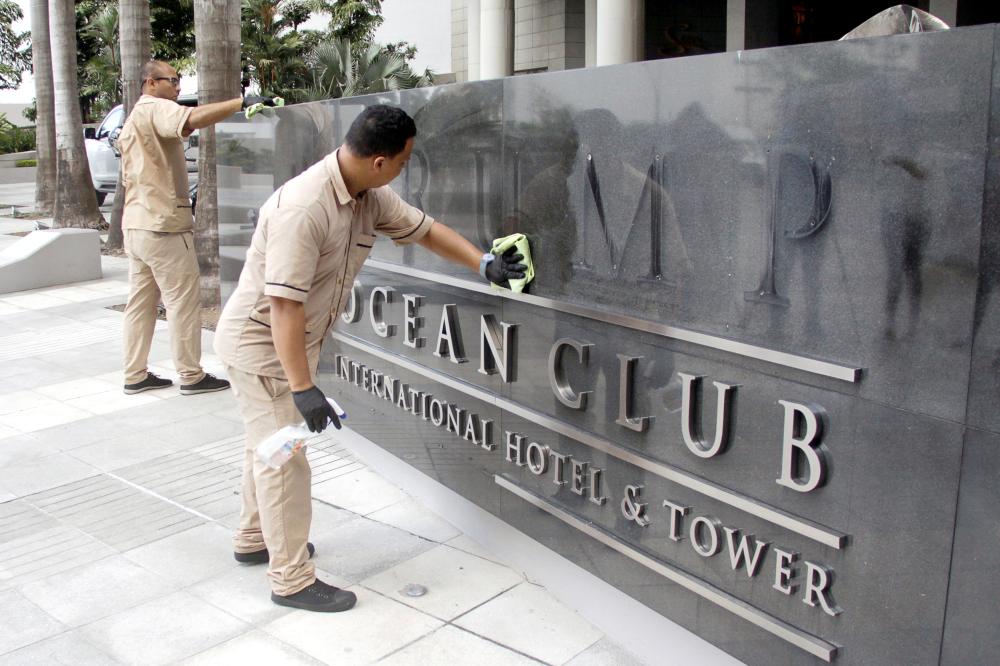 A worker cleans the site where the Trump name was removed from the Trump Ocean Club International Hotel and Tower in Panama City, Panama, on Monday. — Reuters