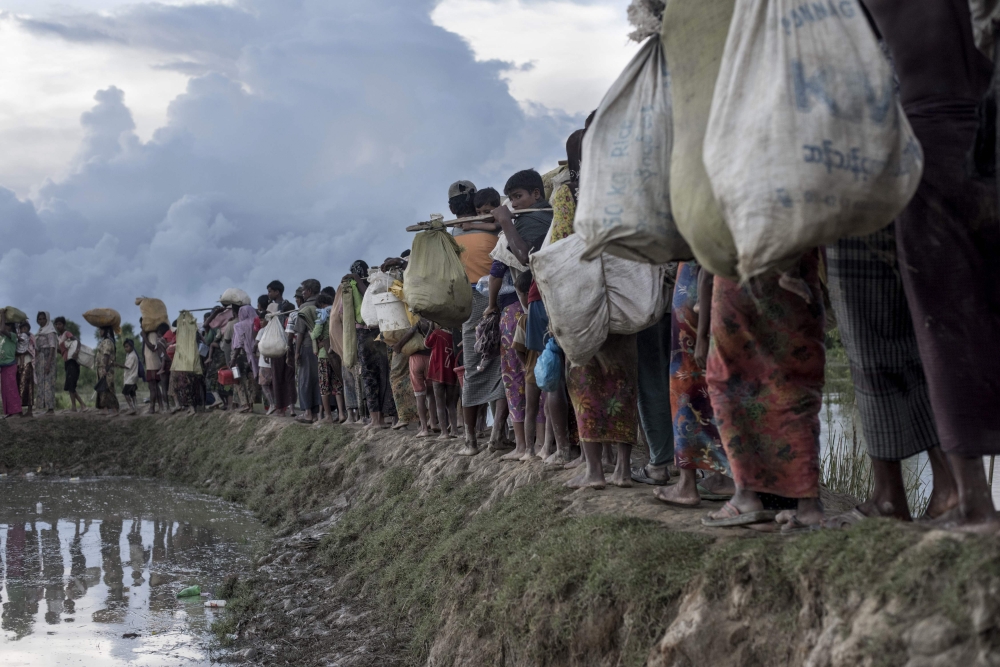 Rohingya refugees walk after crossing the Naf river from Myanmar into Bangladesh in this Oct. 9, 2017 file photo. — AFP