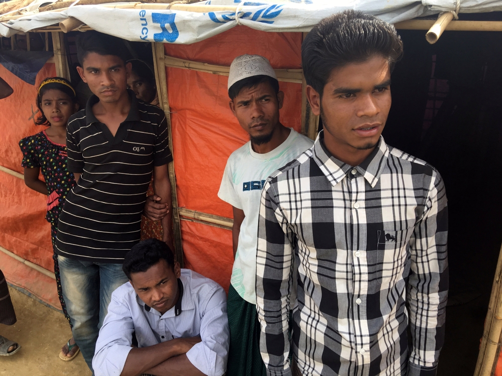 Rohingya refugee Mohammed Hares, 18, right, stands outside his shack on a hillside in Chakmakul camp in southern Bangladesh in this Feb, 13, 2018 file photo. — Reuters