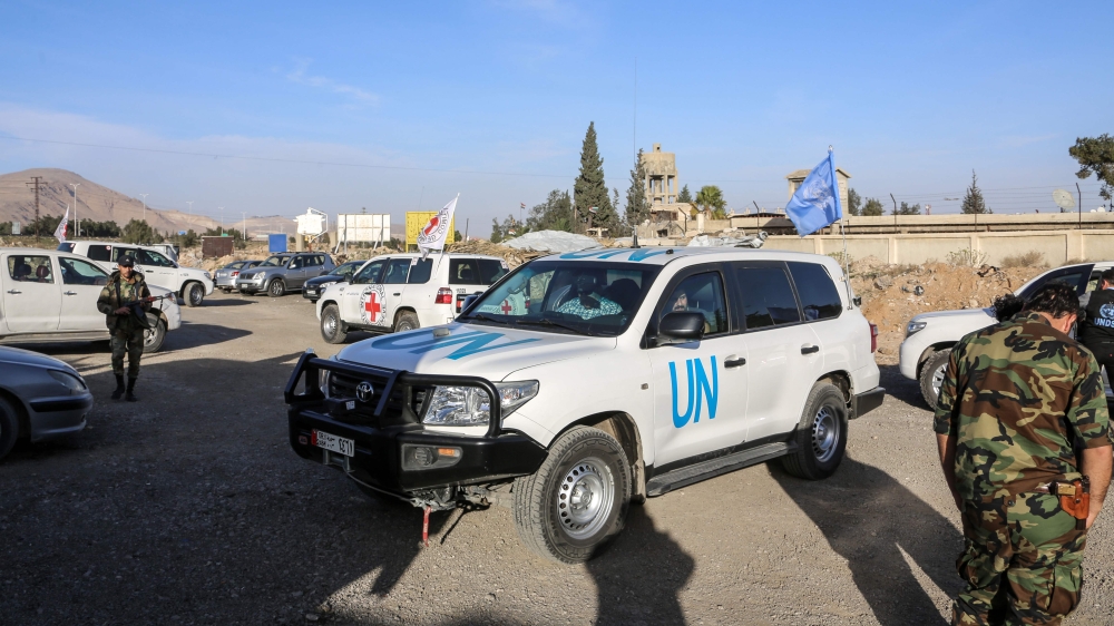 A picture taken on Friday shows UN and International Committee of the Red Cross (ICRC) vehicles waiting to pass through the Wafideen checkpoint on the outskirts of the Syrian capital Damascus into the rebel-held Eastern Ghouta enclave as part of a humanitarian aid convoy. — AFP