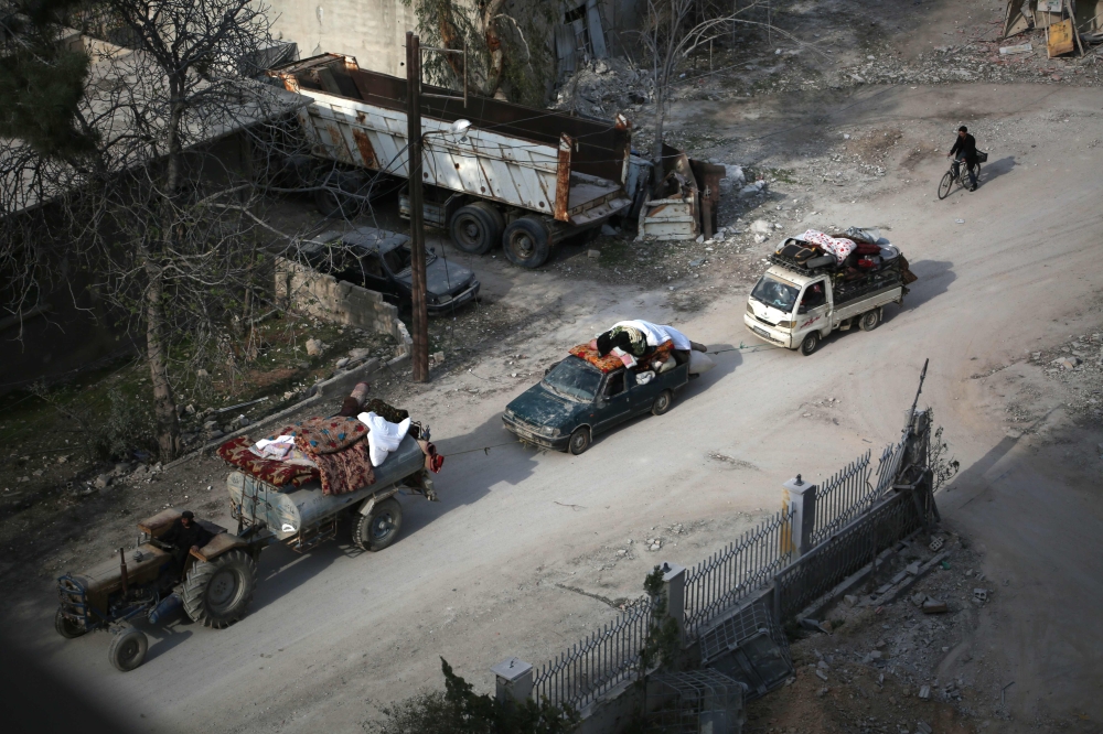 Syrian civilians carry their belongings as they flee following government bombardment on Kafr Batna, in the besieged Eastern Ghouta region on the outskirts of the capital Damascus. — AFP
