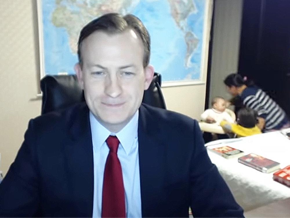 This screengrab shows Robert Kelly during his famous interview with his two children and wife in the background.
