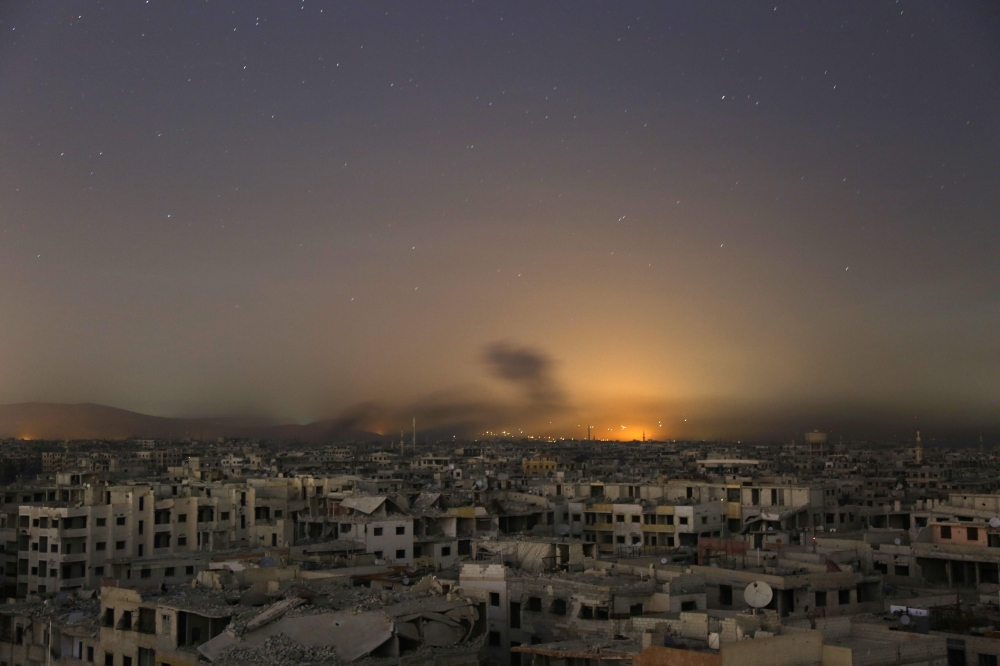 Lights and smoke are seen during Syrian government bombardment on the rebel-controlled town of Arbin, in the besieged Eastern Ghouta region on the outskirts of the capital Damascus. — AFP