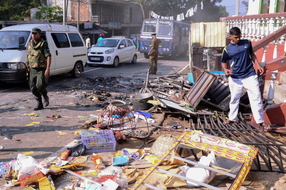 Police commandos patrol next to debris from a damaged shop in the central district of Kandy, Sri Lanka, after a state of emergency was declared, in this March 6, 2018 file photo. — AFP