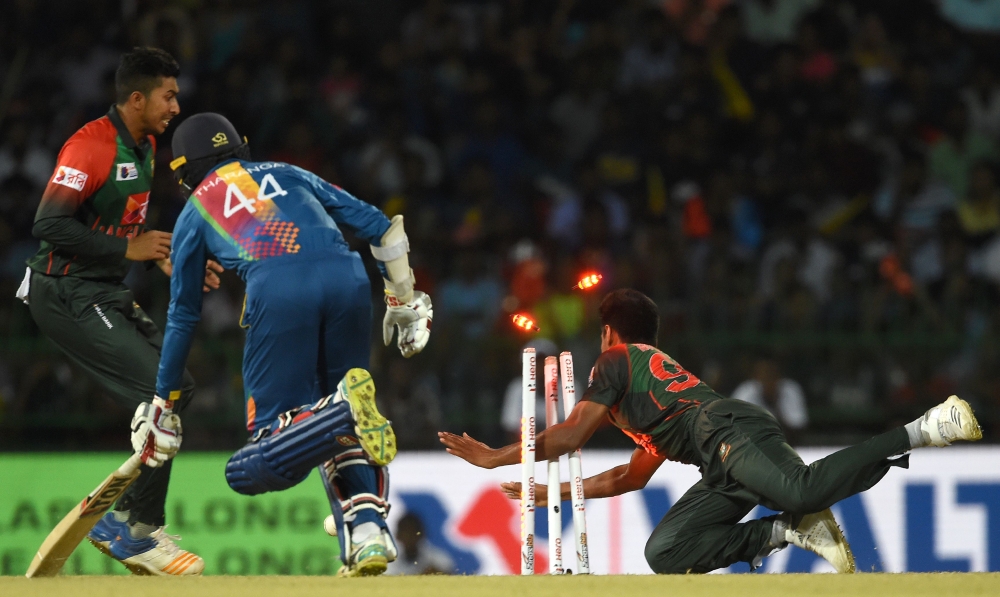 Bangladesh cricketer Mustafizur Rahman (R) dismisses Sri Lanka's Upul Tharanga (C) during the sixth Twenty20 (T20) international cricket match between Bangladesh and Sri Lanka of the tri-nation Nidahas Trophy at the R. Premadasa stadium in Colombo on Friday. — AFP