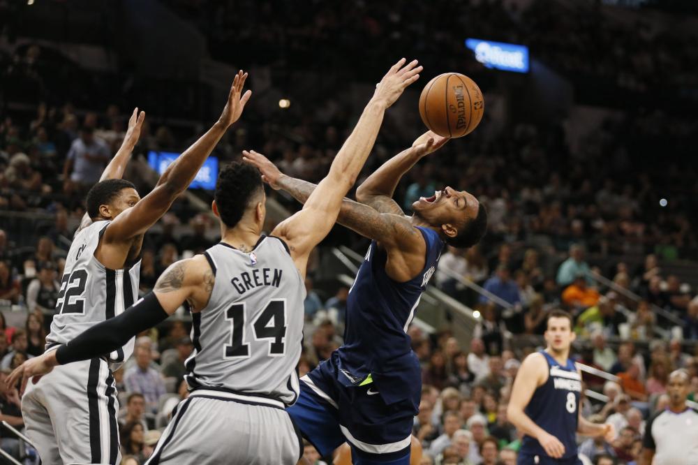 Minnesota Timberwolves’ point guard Jeff Teague (R) is fouled while shooting by San Antonio Spurs’ Danny Green (C) during their NBA game at AT&T Center in San Antonio Saturday. — Reuters