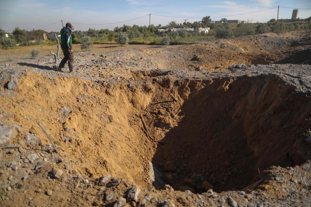 A Palestinian man checks the site of an Israeli air strike in Gaza City on Sunday. — AFP