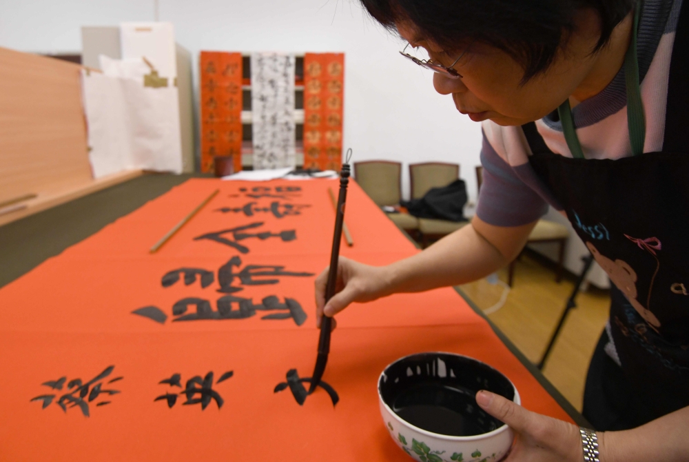 Taiwan presidential calligrapher Yang Shu-wan demonstrates her calligraphy skills in Taipei. Deep in the high-ceilinged corridors of Taiwan's Presidential Office, calligraphers craft messages on behalf of the island's leaders as they seek to keep the traditional art alive. - AFP