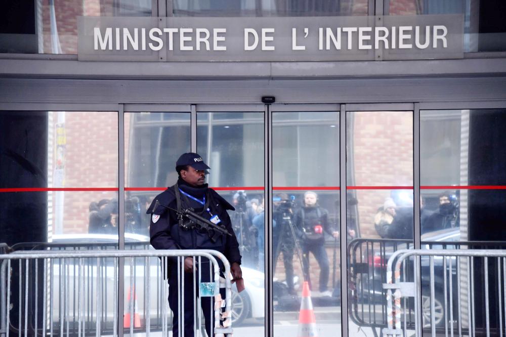 An armed police officer stands guard outside the headquarters of the Central office for the fight against corruption and financial and fiscal crime (OCLCIFF) in Nanterre, outside Paris, during the police custody of the French former president, on Tuesday. — AFP