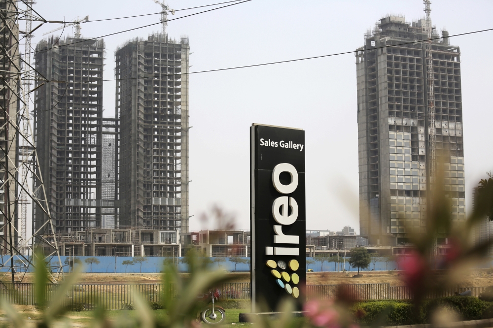 A signboard advertising IREO stands in front of buildings being constructed by the real estate firm in Gurgaon, India, on Tuesday. — AP