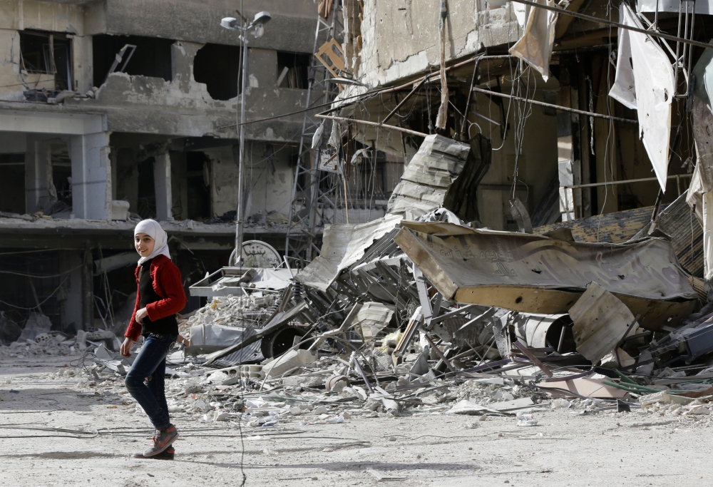 A Syrian girl walks along a destroyed street in the Eastern Ghouta town of Saqba as civilians return to the area after regime forces took control of the southern pocket that was held by the Faylaq Al-Rahman rebel group. — AFP