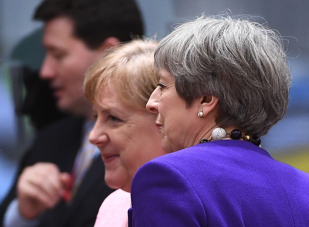 Germany’s Chancellor Angela Merkel, left, and Britain’s Prime Minister Theresa May attend a European leaders summit at the European Council in Brussels on Thursday. — AFP