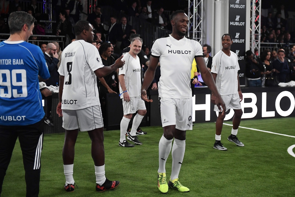 Retired Jamaican Olympic and World champion sprinter Usain Bolt (2R) and French former ioternational Marcel Desailly  (2L) take part in an exhibition football game organized by watchmaker Hublot during the press day on the eve of the opening of the Baselworld watch and jewellery show on Tuesday in Basel. — AFP