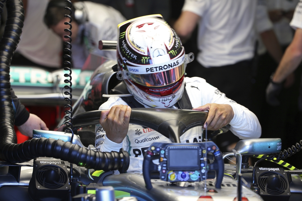 Mercedes driver Lewis Hamilton of Britain struggles to get our of his car at the end of the first practice session at the Australian Formula One Grand Prix in Melbourne, Friday, March 23, 2018. The first race of the 2018 seasons is on Sunday. (AP Photo/Rick Rycroft)