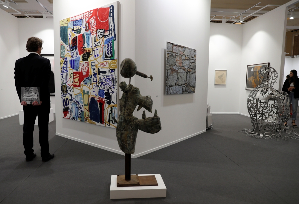 Visitors look at artworks at the annual Art Dubai exhibition in Dubai on Wednesday. — Reuters