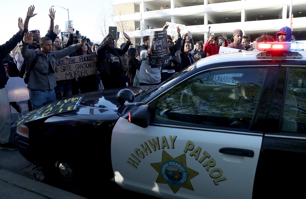 Black Lives Matter protesters surround a California Highway Patrol car as it attempts to drive down a street during a demonstration in Sacramento, California, on Thursday. — AFP