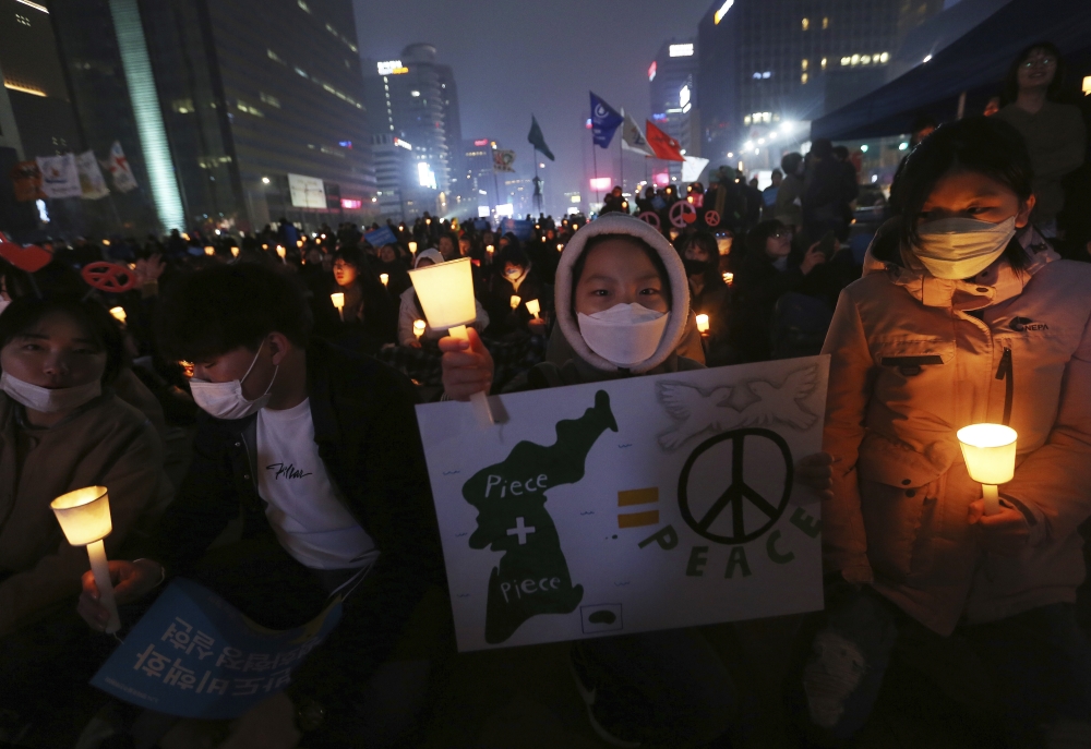 A girl holds a banner during a rally demanding peace on the Korean Peninsula near US Embassy in Seoul, South Korea, on Saturday. — AP