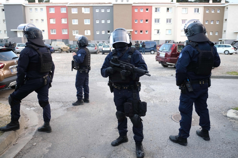 French members of the Research and Intervention Brigade (BRI) secure the area during a search operation at the Ozanam housing estate in Carcassonne, southwestern France, on Friday, following the shooting dead by French security officers of an armed hostage taker who is believed to have links to the estate. — AFP
