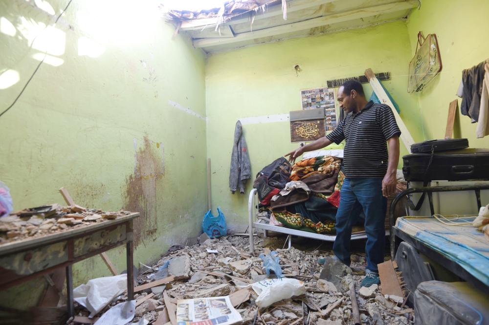 

A picture taken Monday in Um Al-Hammam district in Riyadh shows a man inspecting damages to a home hit by falling shrapnel from Yemeni rebel missiles that were intercepted over the Saudi capital. Spokesman of Civil Defense in Riyadh Maj. Mohammed Al-Hammadi said that the Civil Defense teams in the city responded to the falling shrapnel from missiles after their interception on residential neighborhoods in different locations on Sunday. One of the shrapnel fell on a house in which an Egyptian expat was killed and two of his compatriots were injured, Saudi Press Agency quoted Al-Hammadi as saying. — AFP