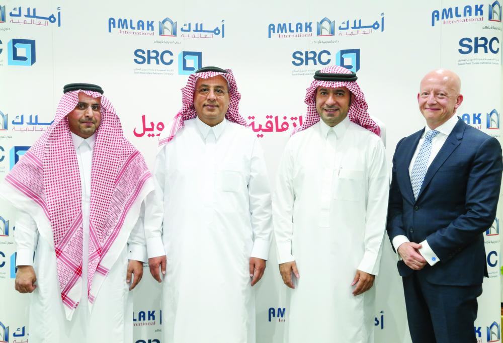 SRC and Amlak International officials at the signing ceremony of the first refinancing deal of 2018. — Courtesy photo