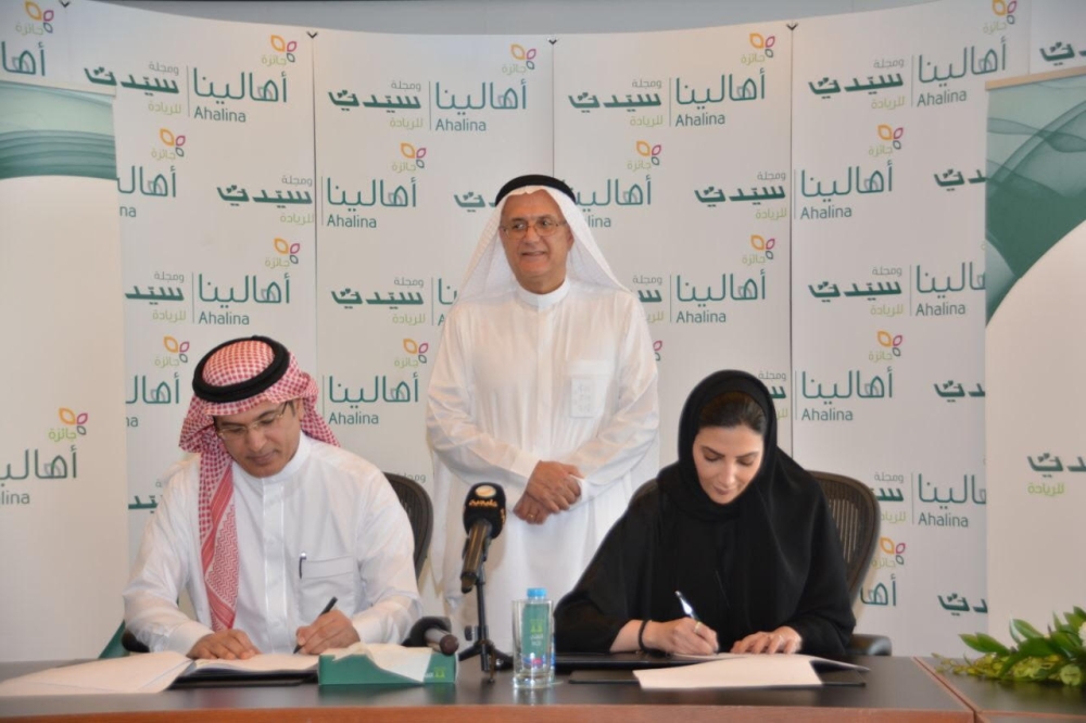 NCB's Basma Al-Jawhari and Mohammad Al-Harthi, editor-in-chief of Sayidaty, sign the deal. — Courtesy photo