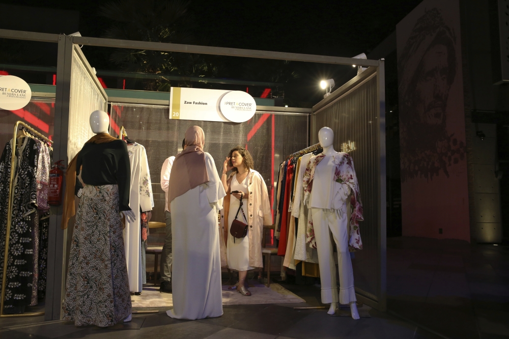 In this combination of four photos taken on Wednesday, models present modest fashion outfits in Dubai. — AP