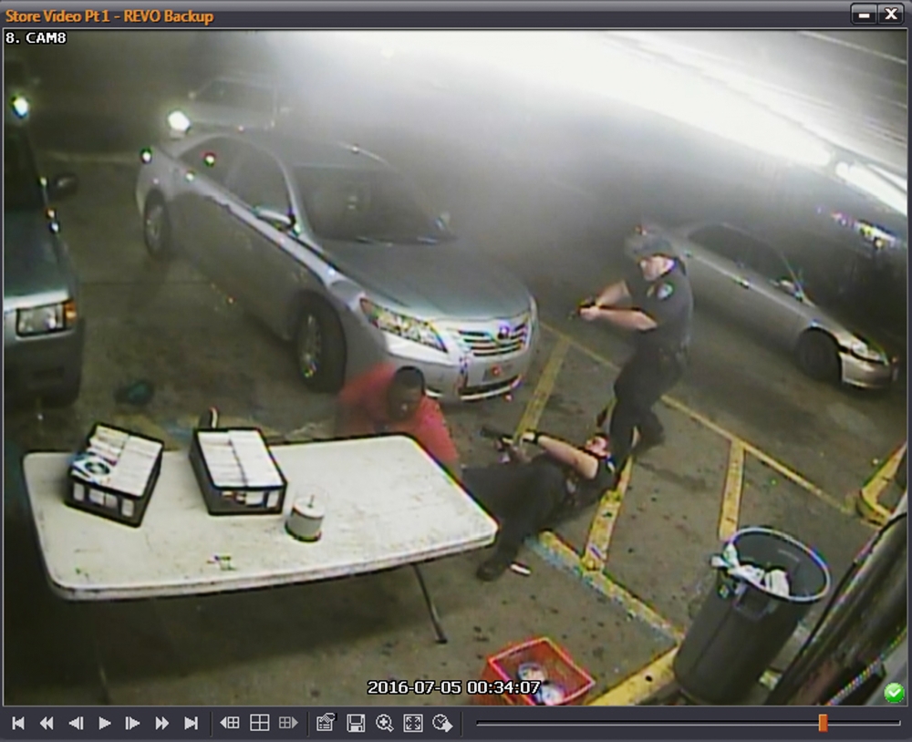 In this still image taken from security camera video provided on Friday by the Baton Rouge Police Department, officers Blane Salamoni and Howie Lake II confront Alton Sterling, left, during a struggle outside the Triple S Food Mart in Baton Rouge, Louisiana, in July 2016. — AP