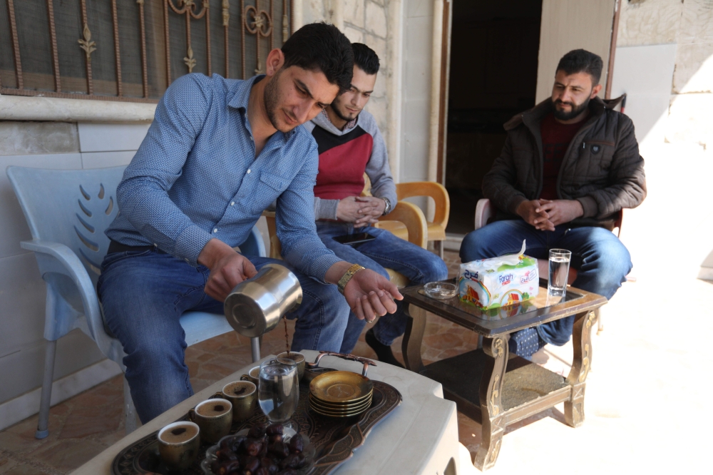 Abdulhamid Yusuf (1st-L), who lost 19 members of his family, including his wife and two children, drinks coffee with friends at his home in Khan Shaykhun. — AFP