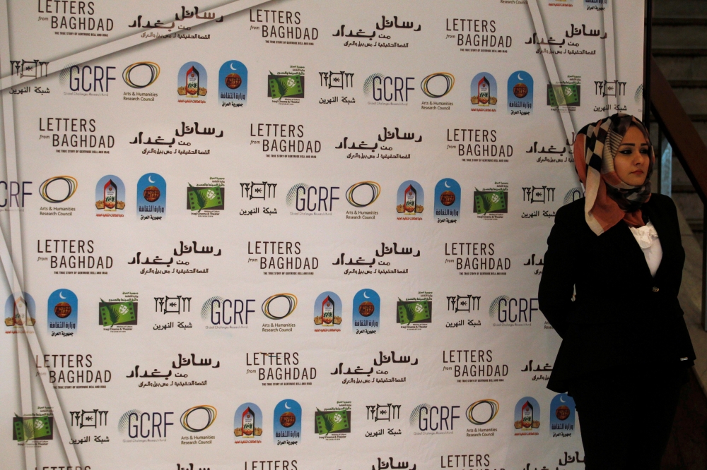 An Iraqi woman stands next to a poster for ''Letters from Baghdad,'' a documentary about Gertrude Bell, at the National Theater of Baghdad, Iraq on Monday. - Reuters