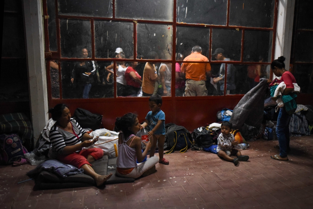 Central American migrants — taking part in a caravan called “Migrant Viacrucis” — rest at a sports center field in Matias Romero, Oaxaca state, Mexico, on Monday. — AFP
