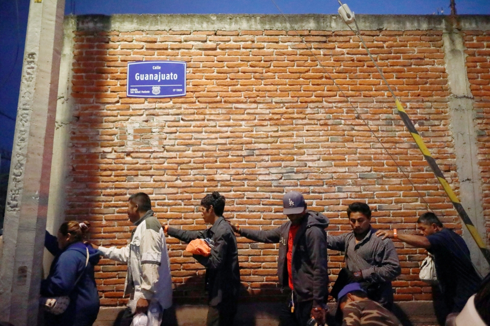 Central American migrants, moving in a caravan through Mexico toward Mexico City, form a line up at a temporary shelter set up for them by the Catholic church, in Puebla, Mexico, on Friday. — Reuters