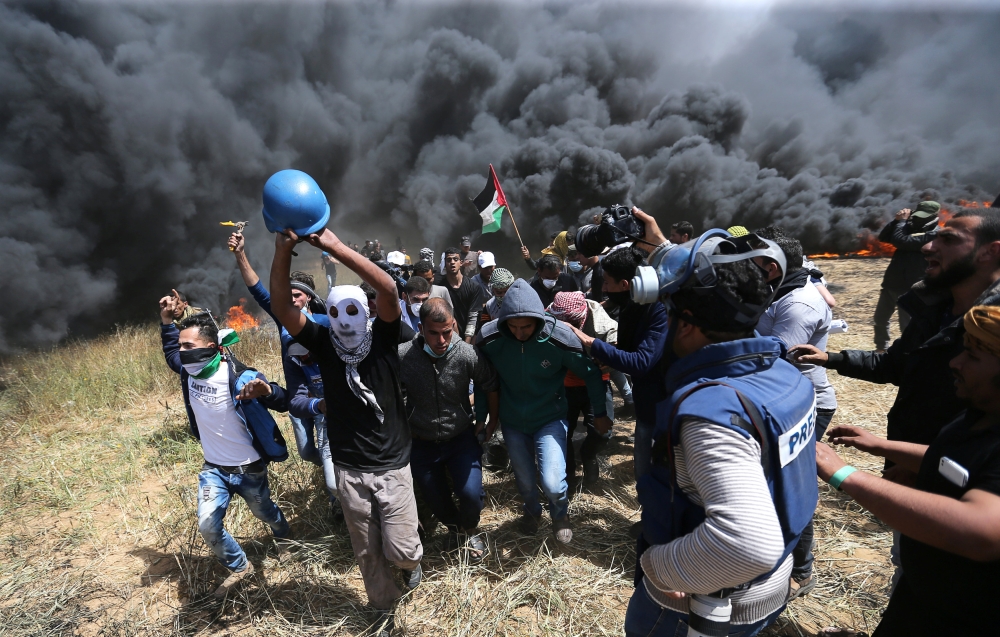 Palestinians evacuate mortally wounded Palestinian journalist Yasser Murtaja, 31, during clashes with Israeli troops at the Israel-Gaza border, in the southern Gaza Strip. — Reuters