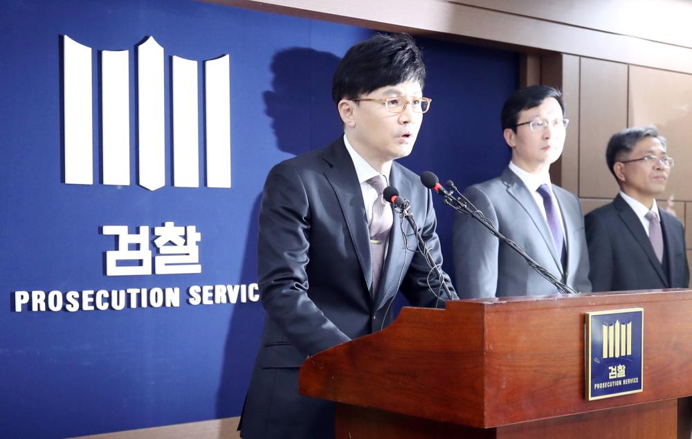 Prosecutor Han Dong-hoon, left, announces the indictment of former President Lee Myung-bak over a string of corruption charges, including bribery, abuse of power and embezzlement, at the Seoul Central District Prosecutors’ Office, on Monday. — EPA