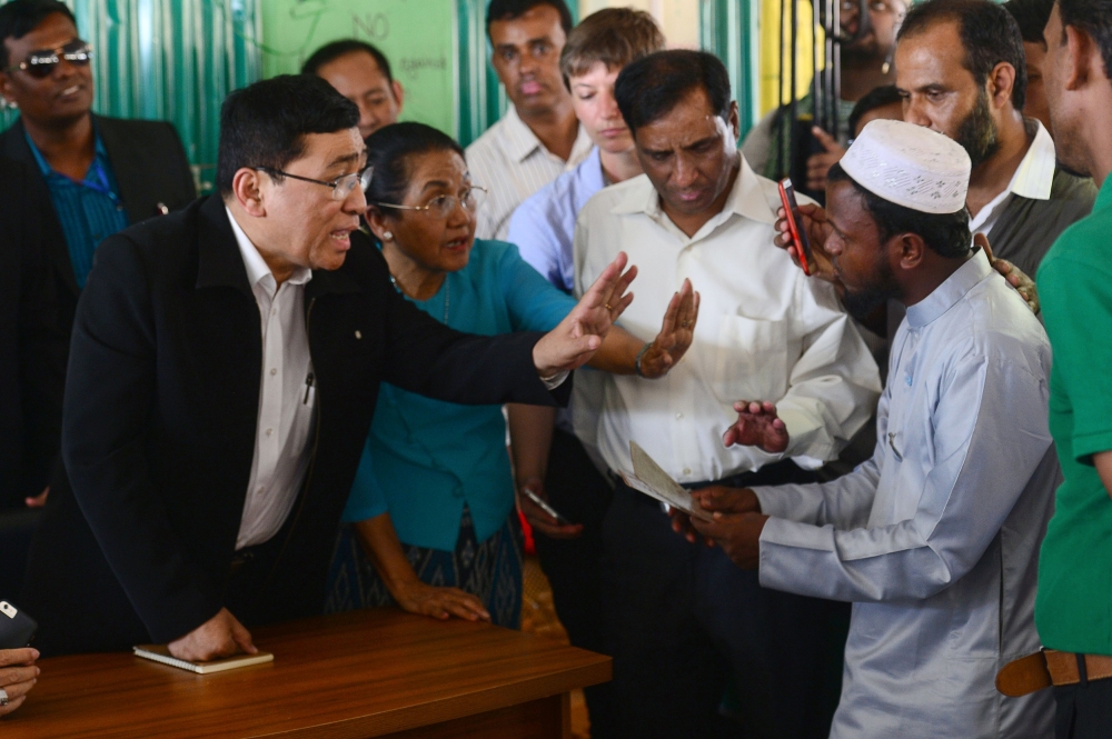 Myanmar Social Welfare Minister Win Myat Aye, left, talks to Rohingya refugees during his visit to the Kutupalong refugee camp in Bangladesh’s Ukhia district on Wednesday. — AFP