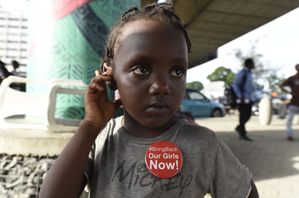 A young girl wears badge to press for the release of the remaining 112 out of 219 kidnapped Chibok schoolgirls ahead of the fourth anniversary of their kidnapping during a vigil in Lagos on Friday. — AFP