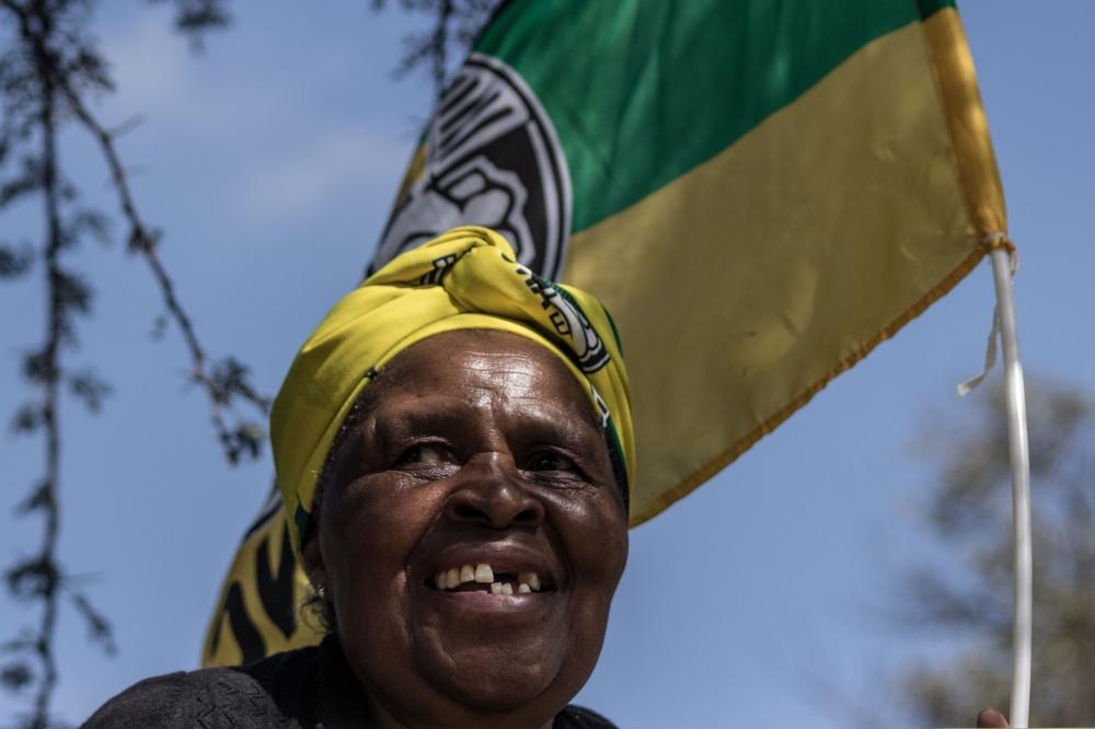 A woman dressed in African National Congress (ANC) regalia waits outside the Fourways Memorial Park in Johannesburg on Saturday, ahead of the burial of anti-apartheid icon Winnie Madikizela-Mandela. South Africans turned out in their thousands to bid final goodbyes to the anti-apartheid icon and Nelson Mandela's former wife who was laid to rest with full state honors. — AFP