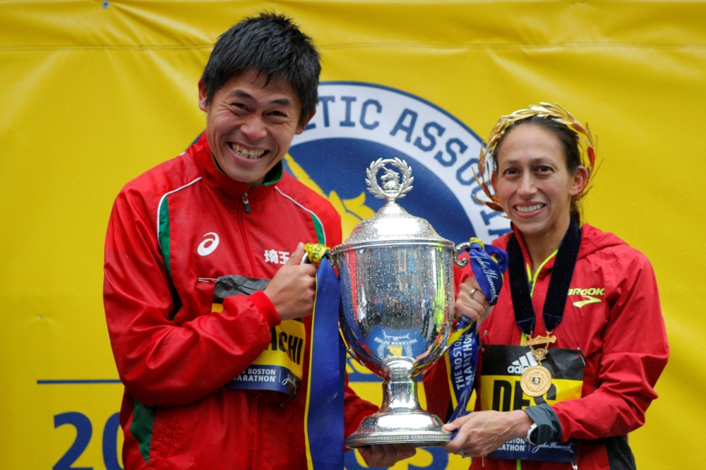 Yuki Kawauchi of Japan and Desiree Linden of the US celebrate with the trophy after winning the men's and women's divisions of the 122nd Boston Marathon in Boston, Massachusetts, US, Monday. — Reuters