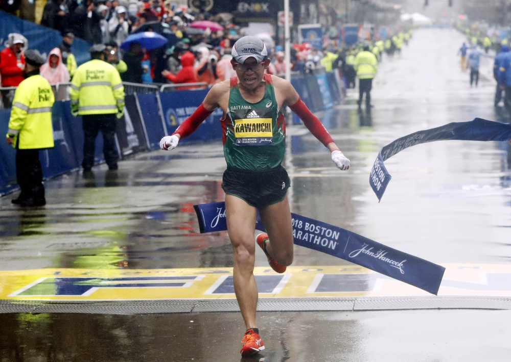 Yuki Kawauchi of Japan and Desiree Linden of the US celebrate with the trophy after winning the men's and women's divisions of the 122nd Boston Marathon in Boston, Massachusetts, US, Monday. — Reuters