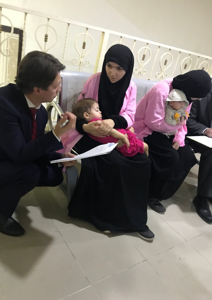 A member of the Russian diplomatic corps (L) talks with two Russian nationals as they attend their trial at the Central penal Court in Baghdad. Two Russian women were sentenced to life in prison for belonging to the Daesh group, the latest in a series of court judgments against militants. — AFP