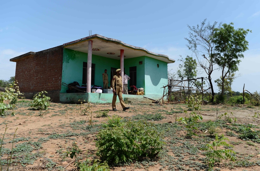 An Indian policeman guards the house of the eight-year-old girl, who was raped and murdered, at Rasana village  in Kathua district of Jammu on Tuesday. — AFP