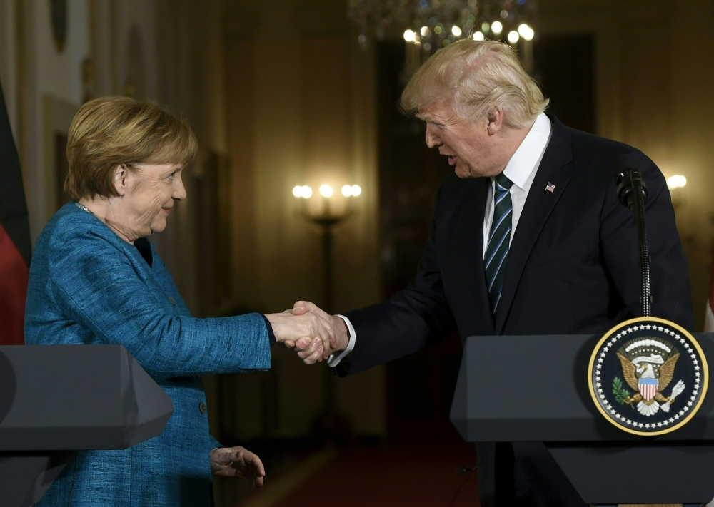 US President Donald Trump and Germany’s Chancellor Angela Merkel shake hands after a press conference in the East Room of the White House in Washington in this March 17, 2017 file photo.  — AFP