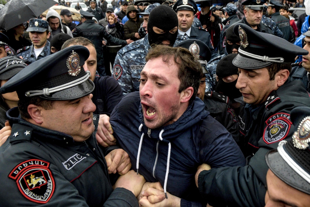 Armenian policemen detain an opposition supporter during a rally in central Yerevan on Saturday. — AFP