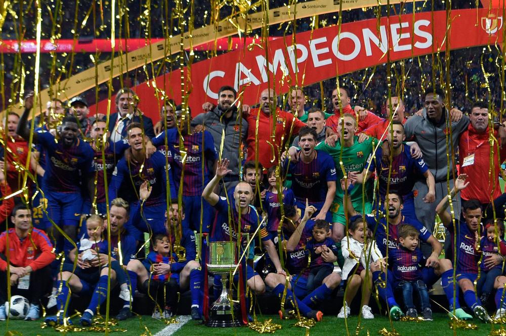 Barcelona’s players pose with the trophy after winning the Spanish Copa del Rey (King’s Cup) final against Sevilla at the Wanda Metropolitano Stadium in Madrid Saturday. — AFP