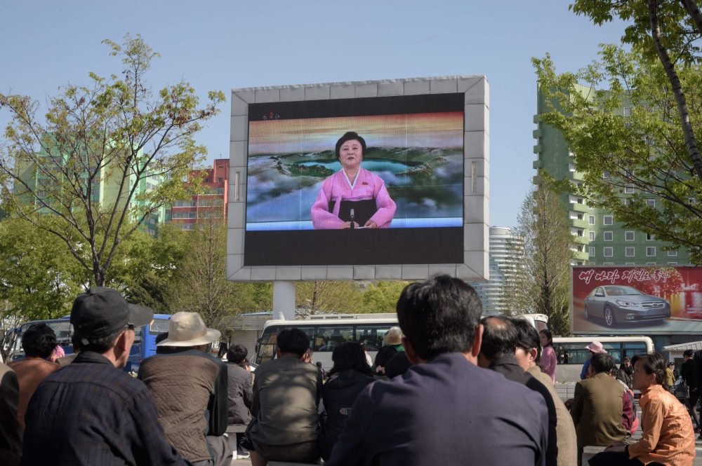 People watch a public television screen showing coverage of the ‘Third Plenary Meeting’ of the 7th central committee of the ruling Workers’ Party, in Pyongyang on Saturday. — AFP