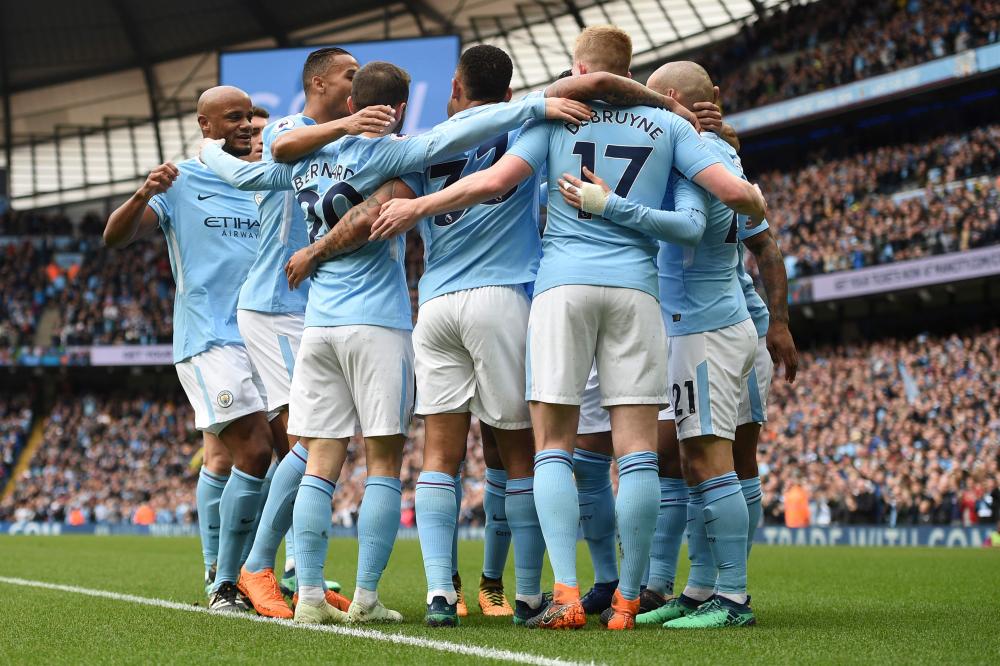 Manchester City players celebrate their Premier League title after beating Swansea at the Etihad Stadium in Manchester Sunday. — AFP 