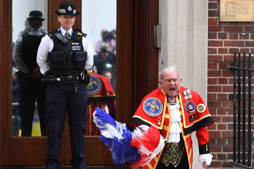 A town crier reads out the news of the birth of a baby boy by Britain's Kate outside the Lindo Wing at St. Mary's Hospital in central London on Monday. - AFP