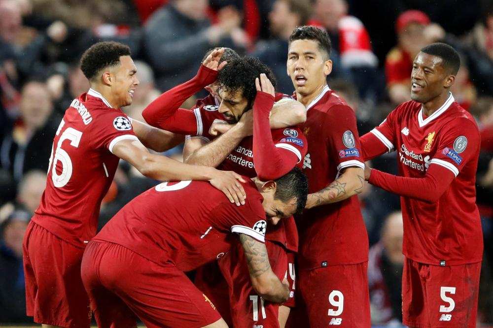 Liverpool’s players congratulate Mohamed Salah after scoring their first goal against AS Roma during their Champions League semifinal first leg match in Liverpool Tuesday. — Reuters 