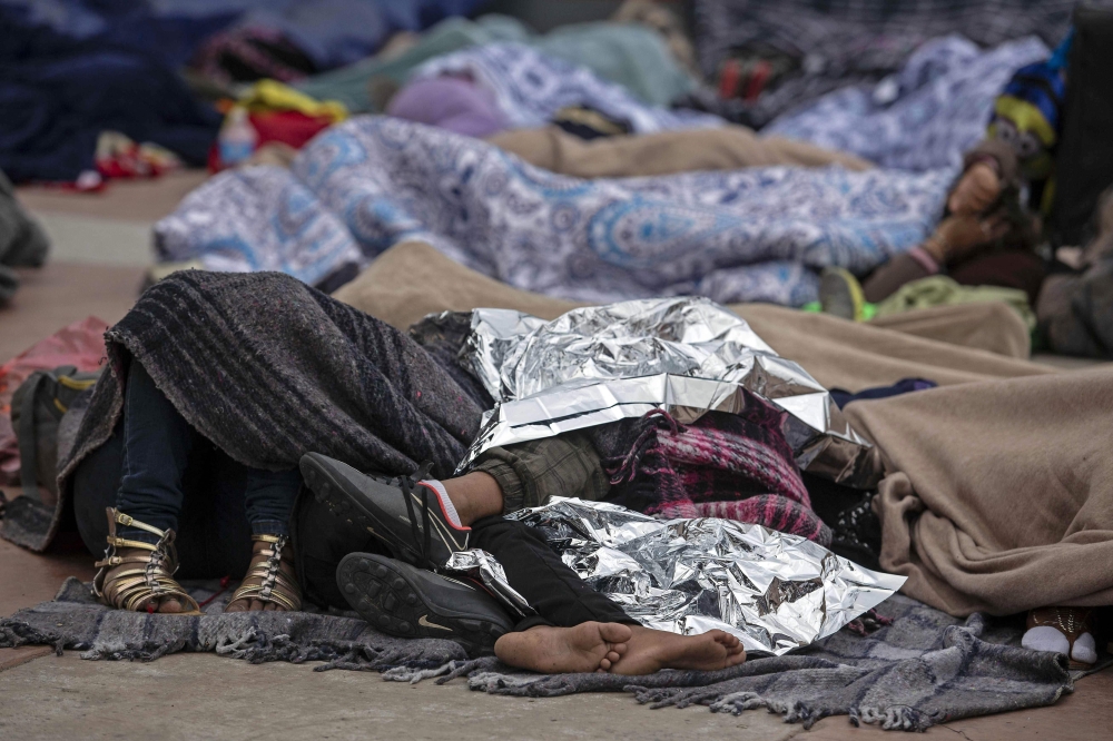Central American migrants traveling in the “Migrant Via Crucis” caravan sleep outside “El Chaparral” port of entry to US while waiting to be received by US authorities, in Tijuana, Baja California State, Mexico, on Monday. — AFP