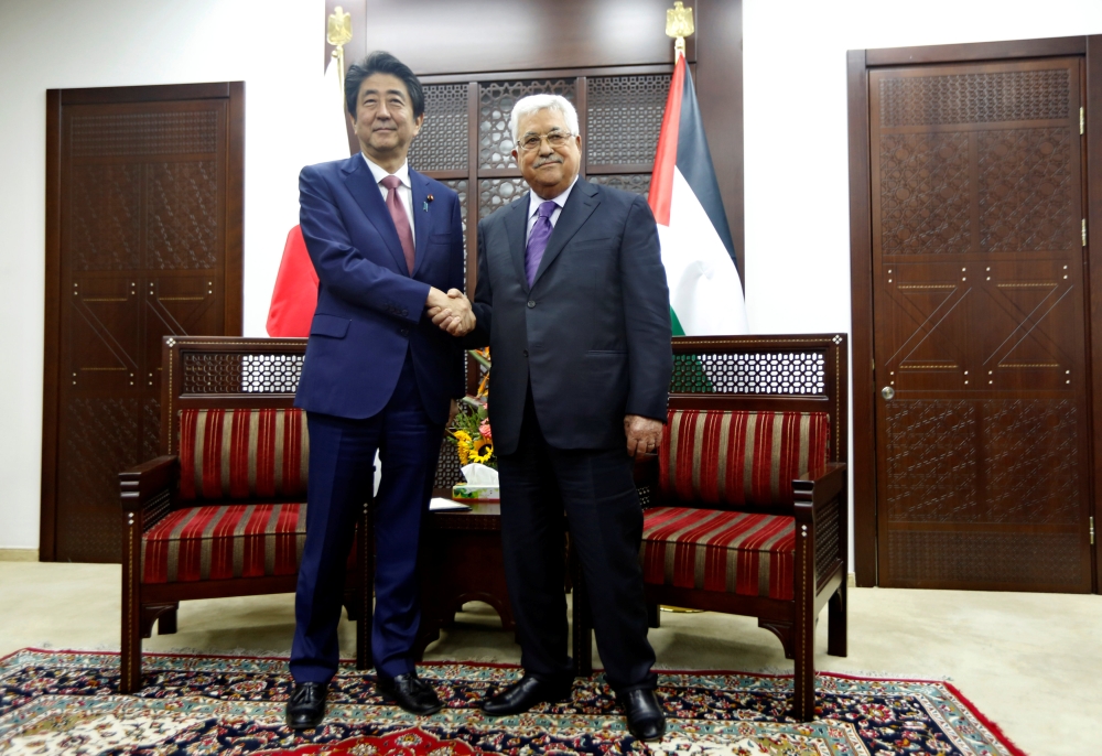 Palestinian President Mahmoud Abbas shakes hands with Japan's Prime Minister Shinzo Abe in Ramallah. — Reuters